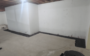 Interior basement waterproofing system installed along foundation walls with drainage solution for moisture protection